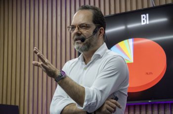 Anderson Hernandes falando com uma tela com BI ao fundo, para ilustrar a importância da contabilidade consultiva