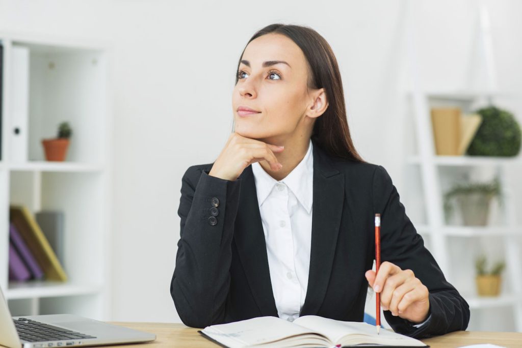 Imagem mostra jovem empresária reflexiva, analisando se vale a pena abrir um escritório de contabilidade
