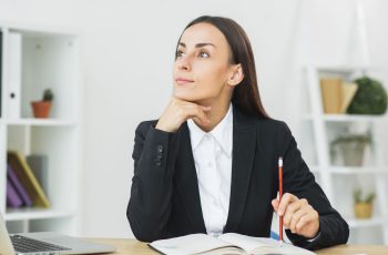 Imagem mostra jovem empresária reflexiva, analisando se vale a pena abrir um escritório de contabilidade