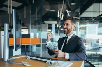 Imagem mostra empresário de sucesso sorrindo com dinheiro na mão, para ilustrar as áreas mais bem pagas da contabilidade