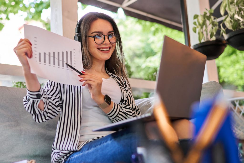 Imagem mostra empresária com gráfico na mão sorrindo, para simular quanto fatura um escritório contábil