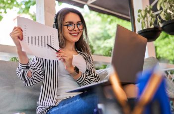 Imagem mostra empresária com gráfico na mão sorrindo, para simular quanto fatura um escritório contábil
